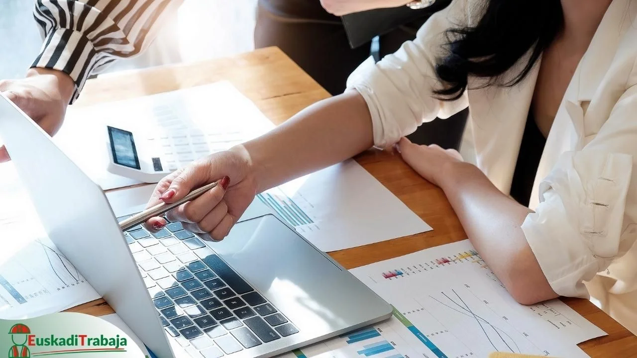 Ofertas de empleo de Lanbide sobre servicios a las empresas en Bizkaia 27 Foto de una mujer ayudando a otra persona con un portátil, en referencia a las ofertas de empleo de Lanbide sobre servicios a las empresas.