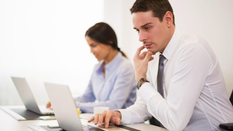 Un hombre y una mujer trabajando con portátiles y haciendo gestiones administrativas.