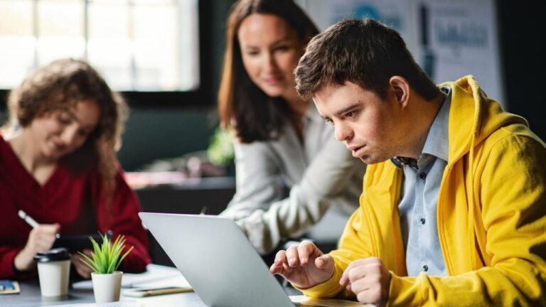 Personas realizando trabajos socioculturales con un portátil.